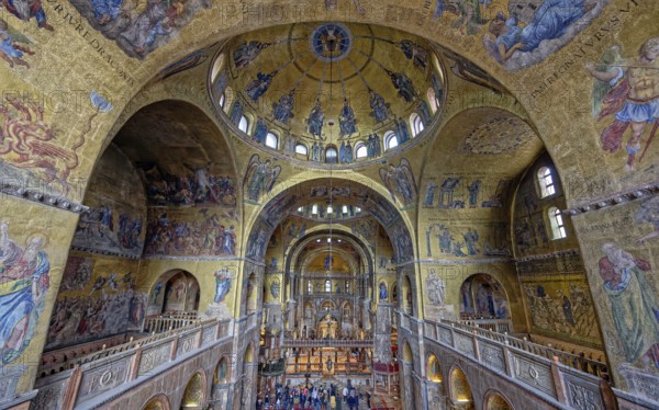 Upper view of a cathedral interior with vaulted ceilings adorned with gold mosaics and religious