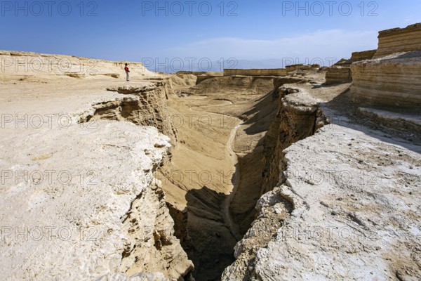 Woman tourist in a red sweater admires the landscape. The Judean Desert. Israel. Interesting walk