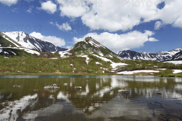 Summer landscape of Kamchatka: view of Mountain Range Vachkazhets and clouds in blue sky,