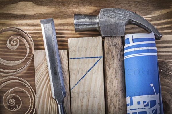 Blue rolled construction drawing claw hammer firmer chisel wooden studs curled shavings on vintage