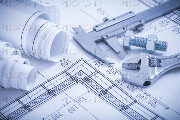 Screw bolt with nut adjustable spanner slide caliper rolls of construction plans on blueprint