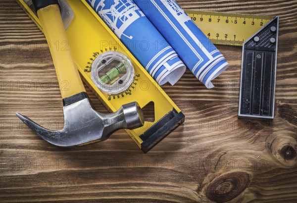 Blue blueprints construction level try square claw hammer on wooden board