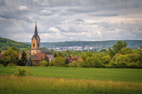 Church of Kunitz in the middle of a rural landscape with a view of the city of Jena, under a cloudy