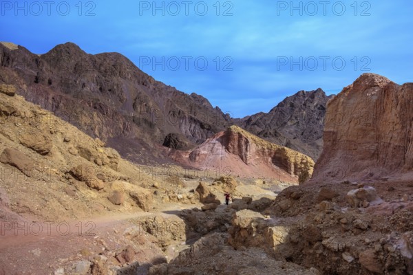 Dry stone desert near the southern seaside resort of Eilat. Woman photographer on a dirt road at