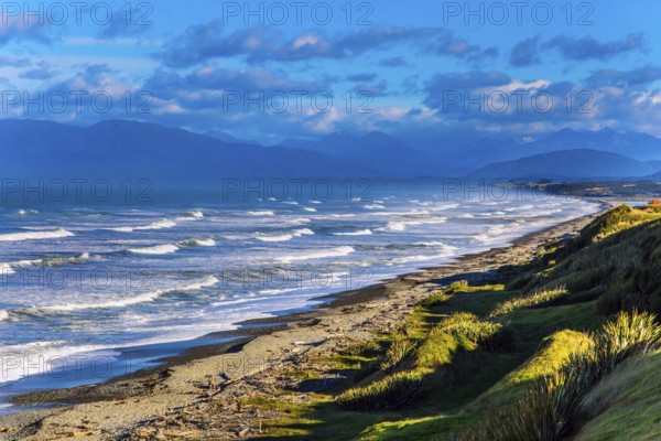 Powerful ocean surf on South island. Sunset. Rocky and stone shores of the ocean. The southernmost