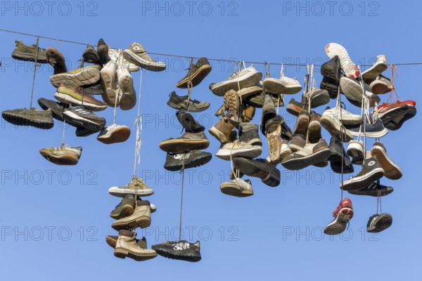 Shoes, boots, trainers, ... hanging on a rope in the air above the Grapengießerstraße medieval old