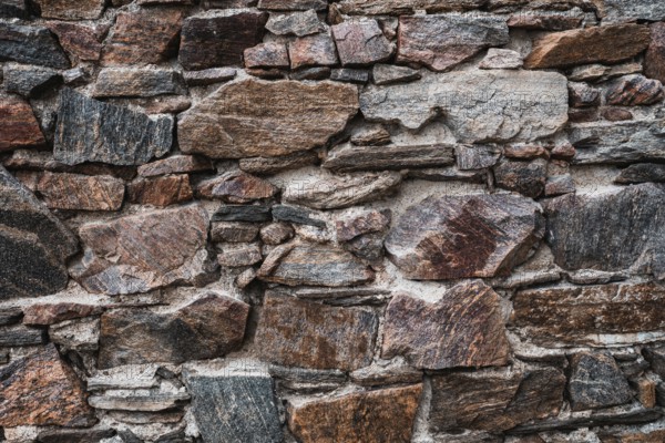 Old stone wall at the castle ruins. Texture of old weathered medieval stone wall