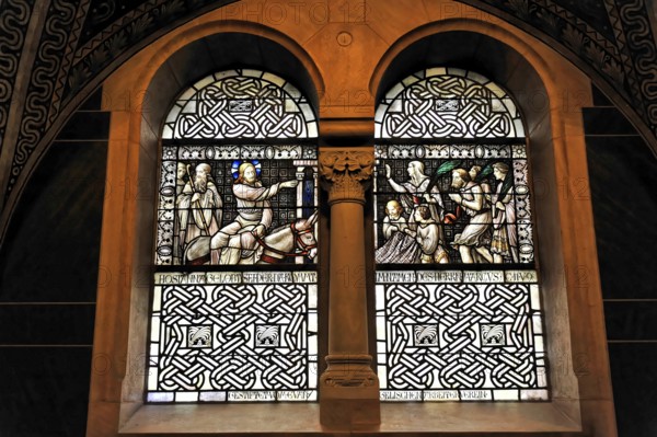 Stained glass window with sacred scenes and filigree stained glass in a church wall, Bad Homburg v.