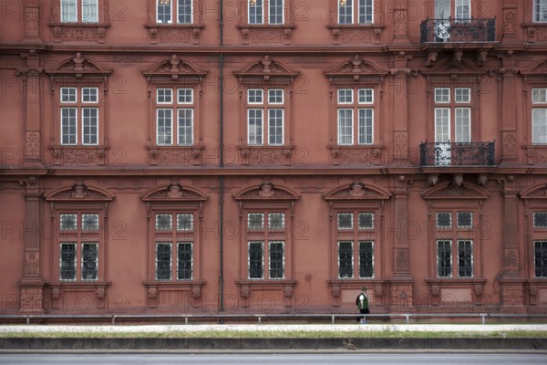 Mainz, Germany - June 24, 2015: A tourist wearing a green waistcoat and hiking clothes walks along