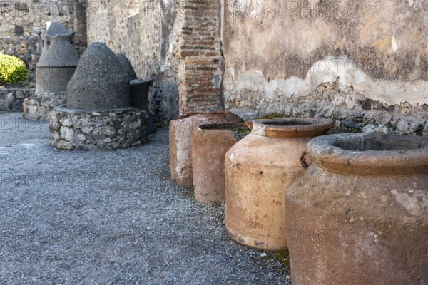 POMPEII, ITALY, MAY 04, 2022, Big clay amphoras buried into the soil of an ancient Pompeian