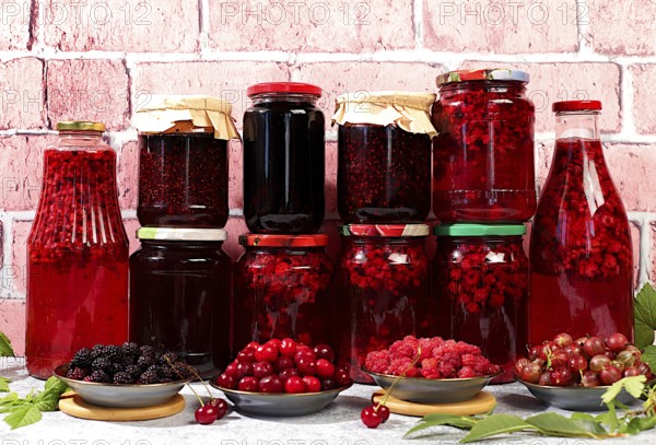 Jars with raspberry, cherry, gooseberry jam and compote on kitchen background with leaves and fresh