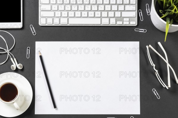 Top view of modern workplace with blank paper sheet. Flat lay black surface with smartphone,