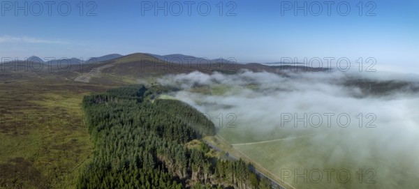 Coastal fog in the Scottish Highlands with hills, in the background prominent peak of Morven,