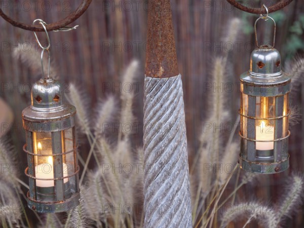 Rustic metal lanterns with burning candles that provide a warm source of light, weseke,