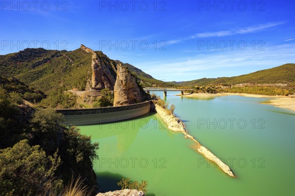 Picturesque conical rocks and a bridge over the reservoir. Magnificent dam collects the water of