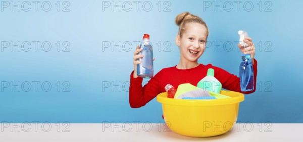 Isolated on blue, cheerful girl in red pullover with fair-haired updo, holding in both hands a