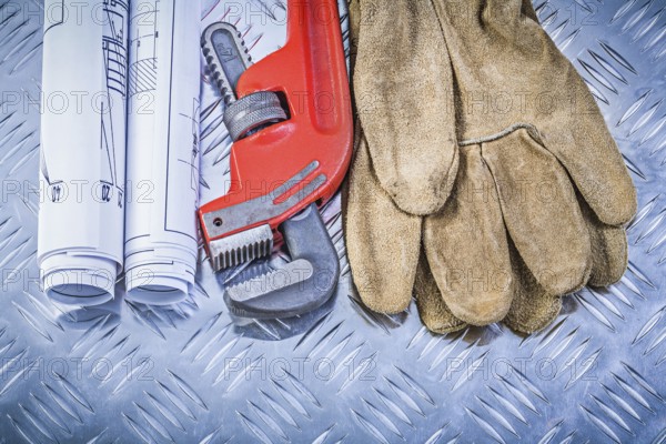 Monkey wrench construction drawings leather safety gloves on corrugated metal background building