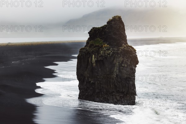 Detail of Arnardrangur rock in the middle of peninsula near Reynisfjara Beach view point Dyrholaey