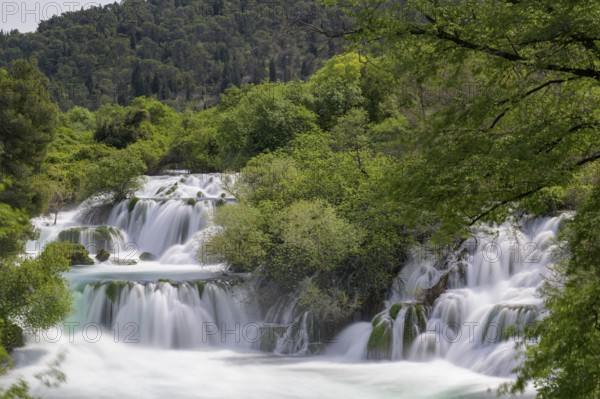 Several waterfalls flow through a lushly wooded hilly landscape, Krka Krka Waterfalls National