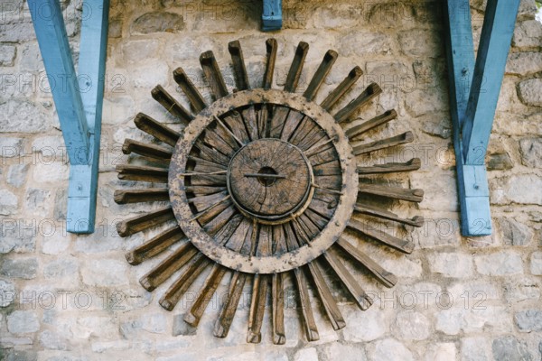 The wheel of a water mill. The old wooden wheel of the water mill is used as an element of decor on