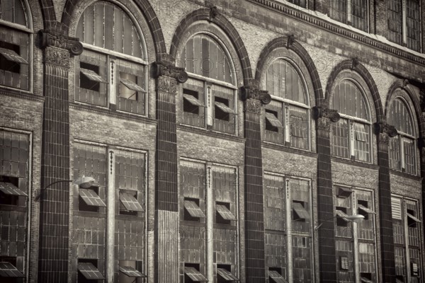 Old power plant - windows and brick walls with sandstone decoration, sepia toned black and white