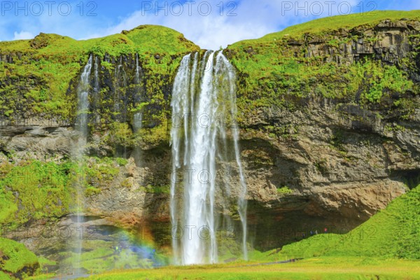 The famous Seljalandsfoss waterfall. Travel to exotic Iceland. Magnificent rainbow appears in the