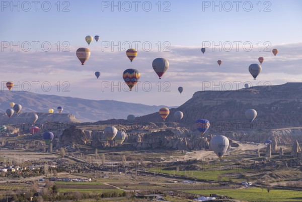 A picture of colorful hot air balloons flying over the landscape of Goreme Historical National Park