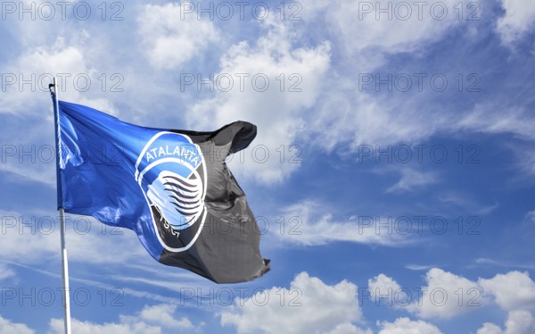 Atalanta flag waving against blue sky with white clouds. Space for text. Bergamo, ITALY - December