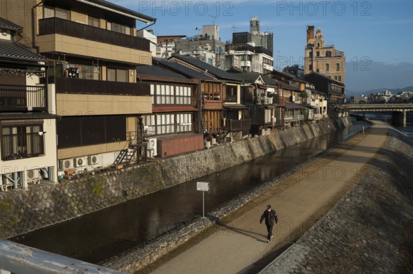 26.12.2017, Kyoto, Japan, Asia, A man walks along the banks of the Kamo River in Kyoto early in the