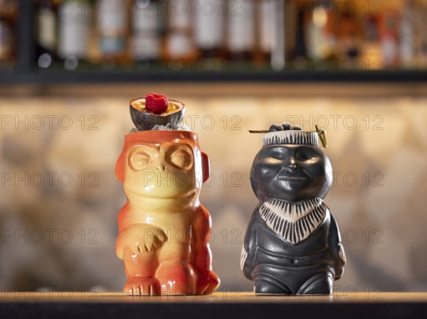 Tiki Drink Cocktails. Two tropical tiki cocktails on bar counter. Tiki cocktails on bar in night