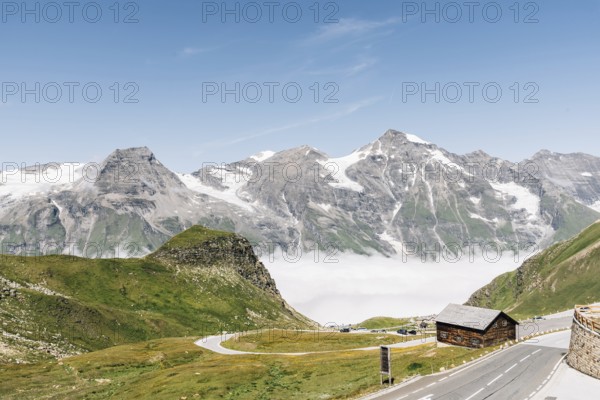Scenic view of Alpine road through valley with sea of clouds. Grossglockner, Austria. Space for
