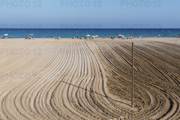 Alicante, Spain, October 13, 2023: Furrows in the sand from sand cleaning raking in the beach of