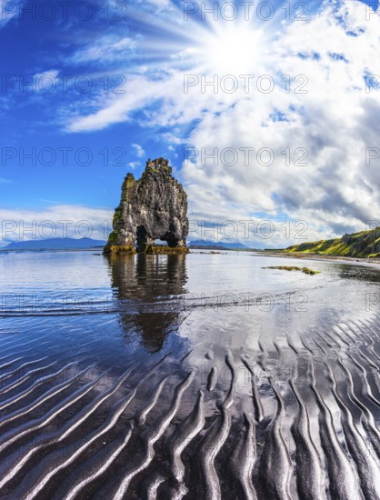 Pale northern sun of Iceland at sunset. The Basalt rock - Elephant Hvitsercur during an ocean