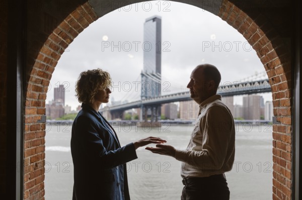 People by the window with Manhattan Bridge in the background, Brooklyn District in New York City -