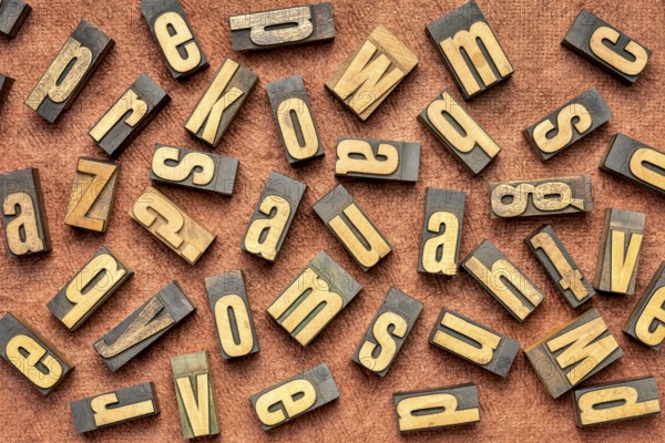 Random letters overhead background - vintage letterpress wood type (inverted image) against brown