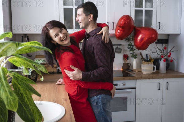 Man and woman in love date at home in kitchen happy hugs. Valentine's Day, happy couple, love story