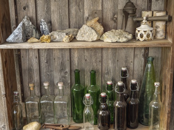 Shelves with bottles and stones on a rustic wooden wall, antique atmosphere, borken, münsterland,