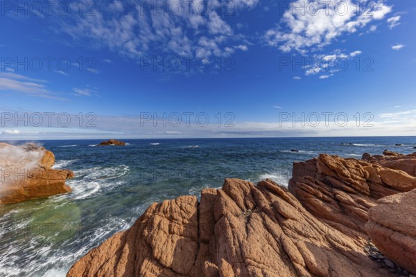Coastal landscape with red rocks and surf in blue sky and sunshine, Spiaggia di Cala E'Luas,