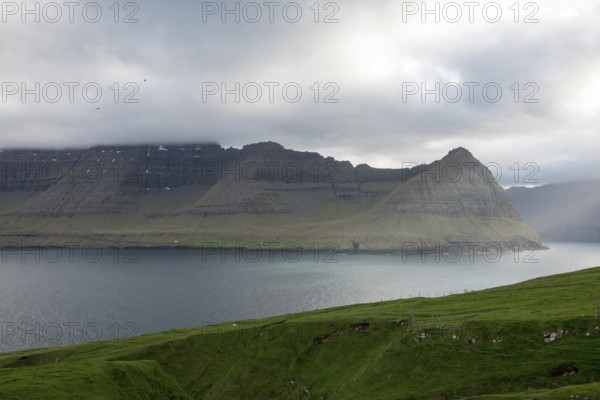 Typical landscape on the Faroe Islands, with green grass and rocks as seen from Vidareidi,