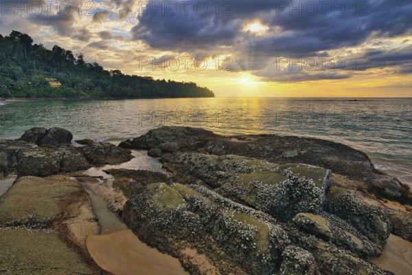 Tropical sea beach sunset with rock coast and ocean wave at Khao Lak, Phang Nga Thailand nature