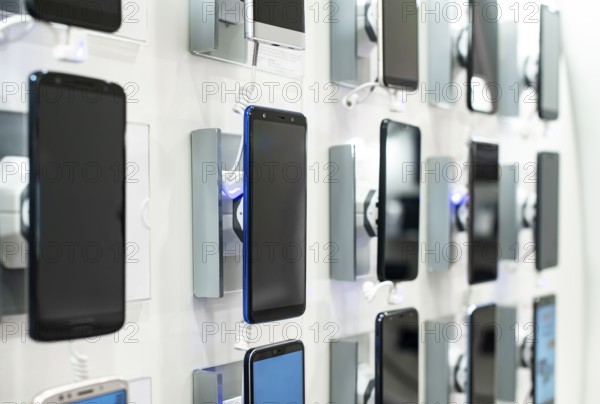 Smartphones on shelf in the store. Concept for communications and technology. Buying mobile phone
