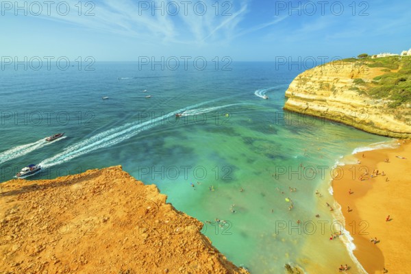 Aerial view of golden cliffs of Praia de Benagil in Algarve near Lagoa, Portugal, Europe. Boat