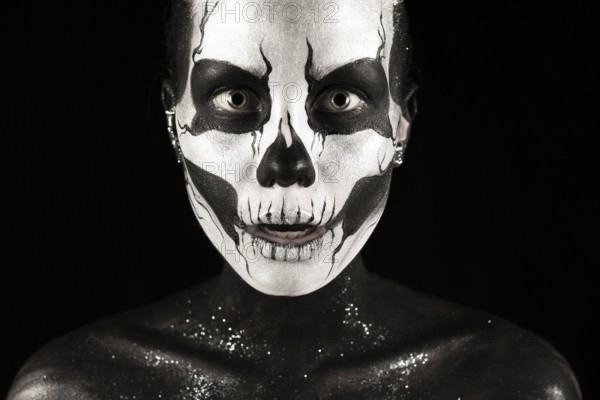 Isolated on black, closeup picture, beautiful young blonde caucasian woman with scull body art,