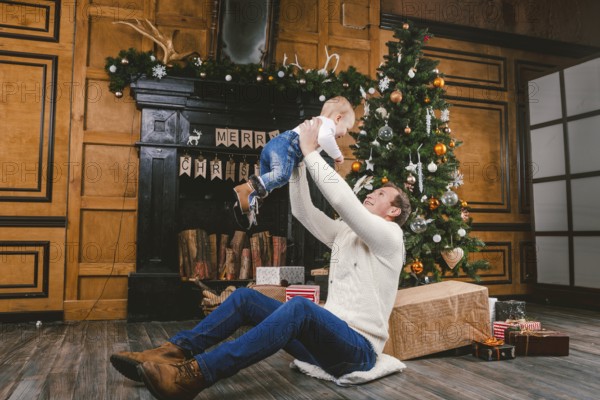 Happy father and son at home near Christmas tree. New Year and Christmas theme. Holiday mood.