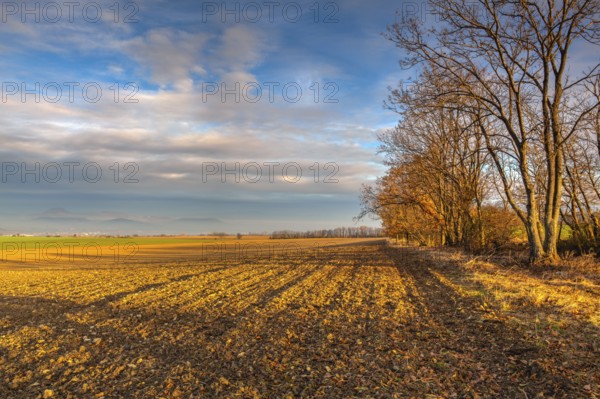 Autumn morning landscape over the city of Louny. Autumn plowed field at amazing sunrise. Czech