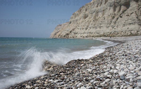 Empty pebble tropical beach under white cliffs against blue sky. Pissouri coastline Limassol Cyprus