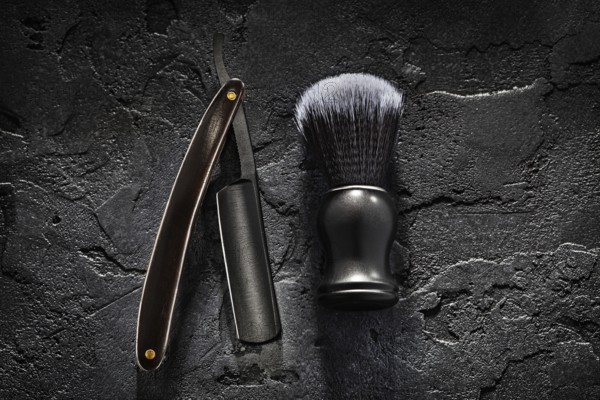 Black Barber Tools. Shaving Brush And Opened Straight Razor With Classic Wooden Handle On Abstract