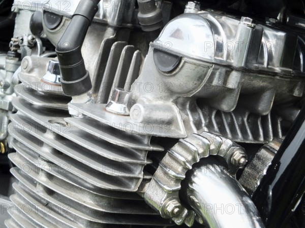 Close up detail of the engine of an old vintage motorcycle with black frame and shiny chrome