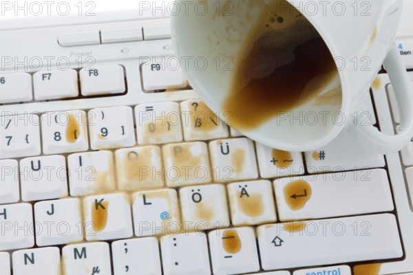 Cup of coffee spilled on a computer keyboard. Damage for insurance, Cup of coffee spilled on a