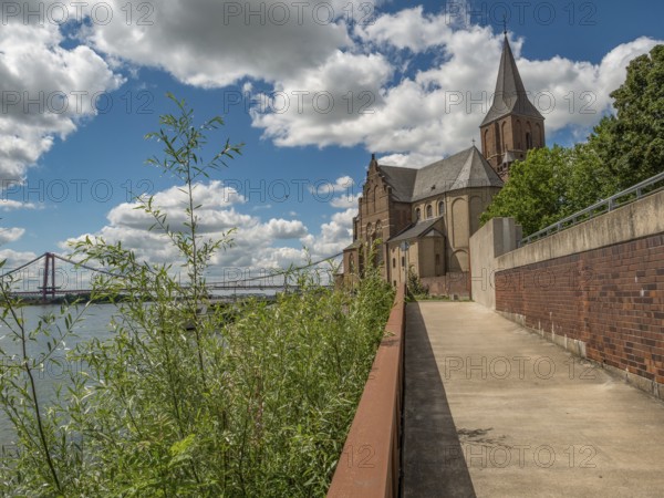 Walkway along a church, in the background a bridge and clouds in the blue sky, emmerich, lower